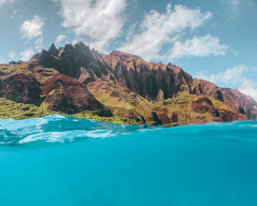 Breathtaking view of turquoise ocean water and rugged cliffs under bright summer sky.