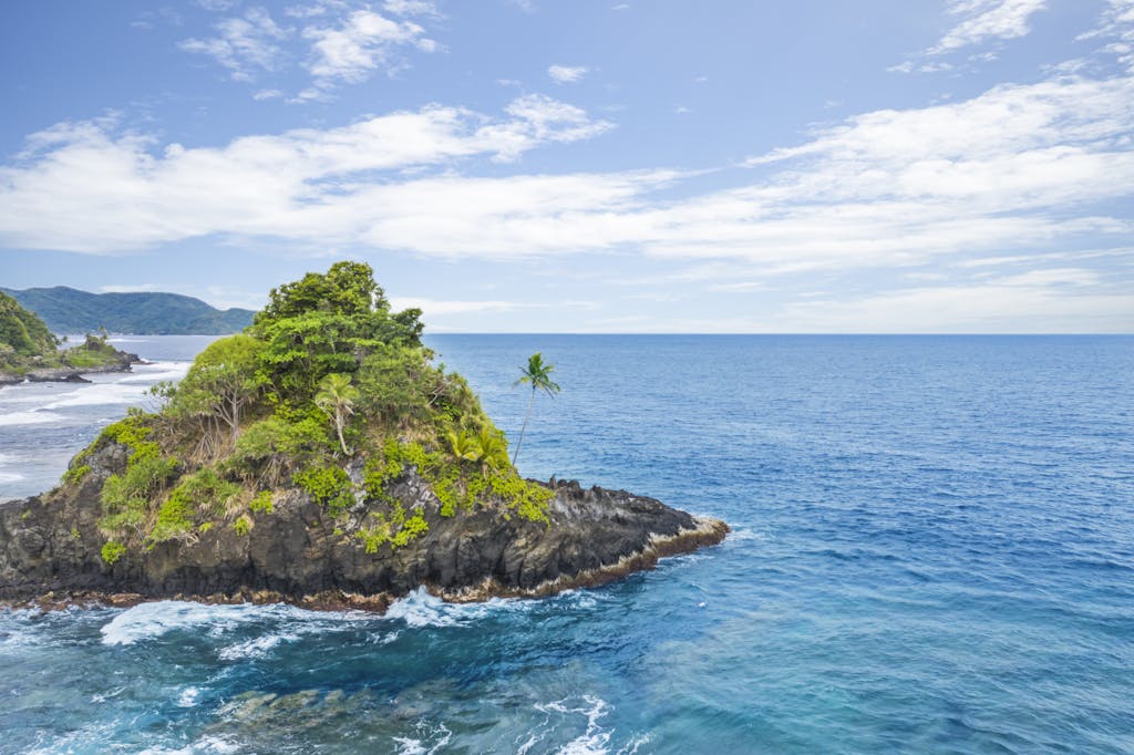 Explore the stunning Alega Beach with vibrant turquoise waters and lush greenery in American Samoa.
