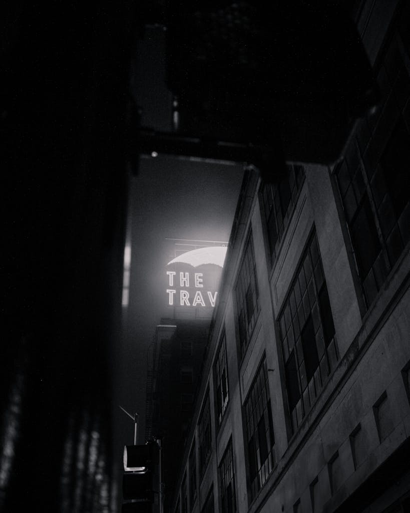Moody night scene in Des Moines featuring an illuminated building sign in black and white.