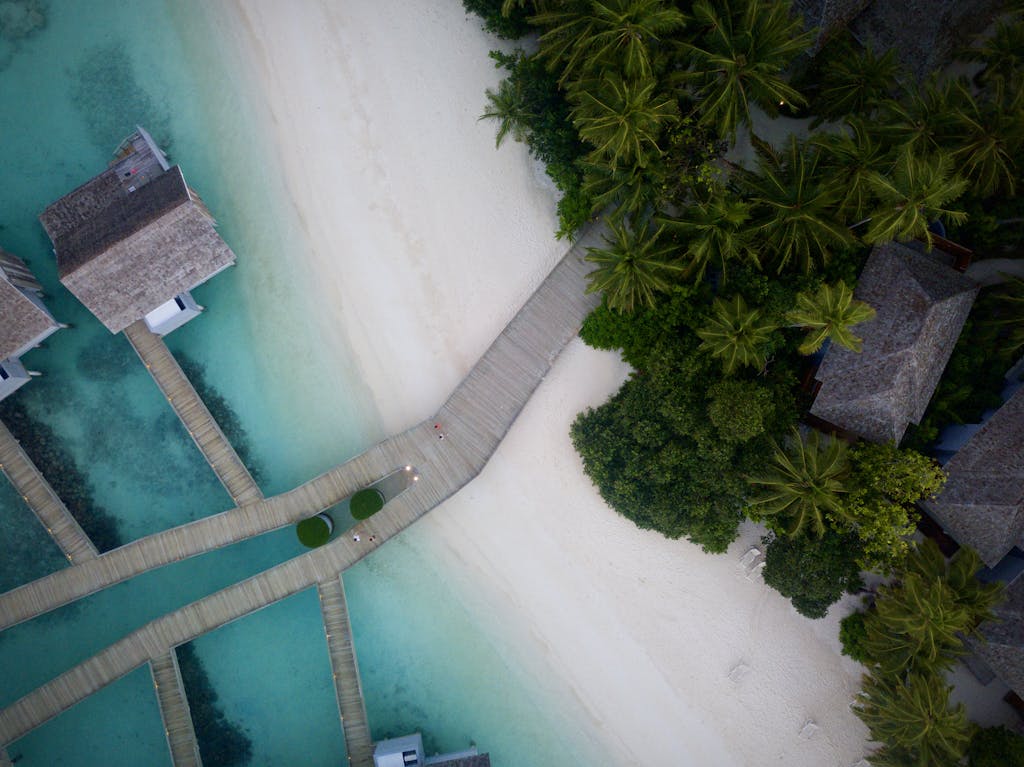 A stunning aerial view of a tropical beach resort with turquoise waters and lush greenery.