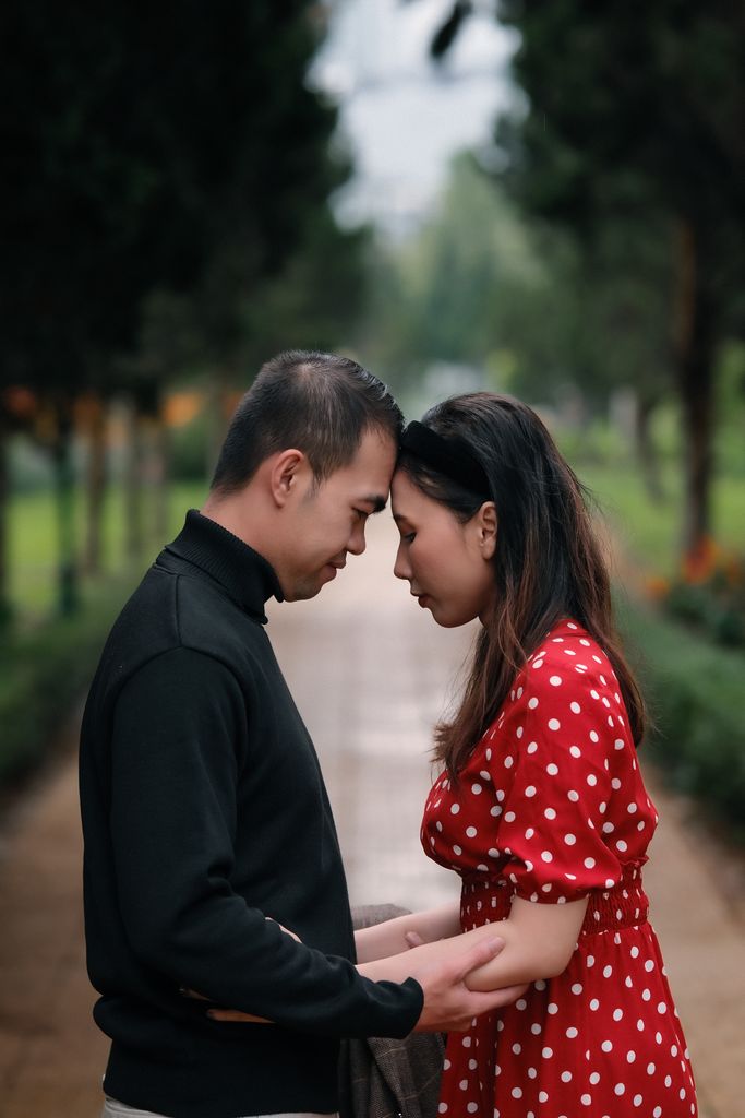 A romantic couple shares an intimate moment in a lush park, illustrating love and connection.